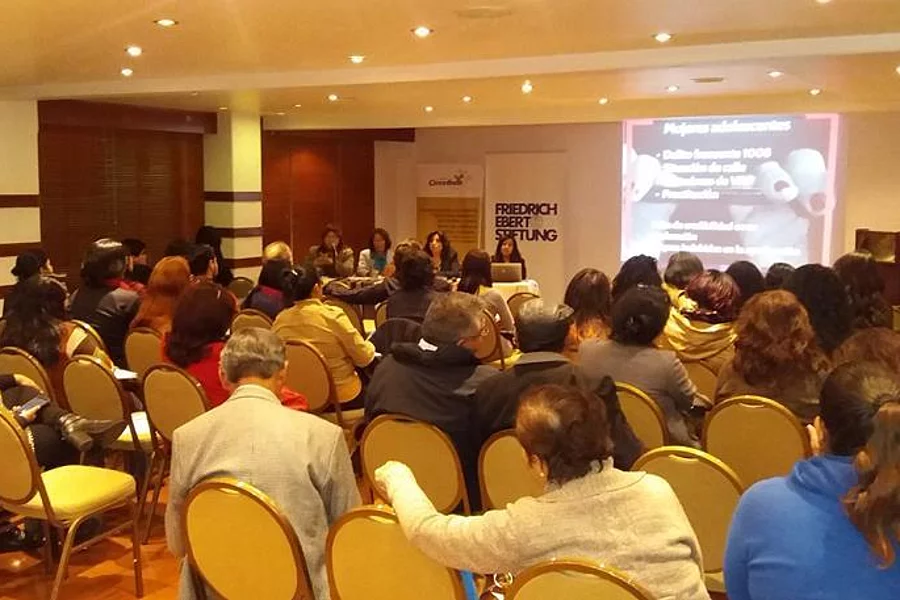 Los participantes escuchan a las ponentes en una sala de eventos.